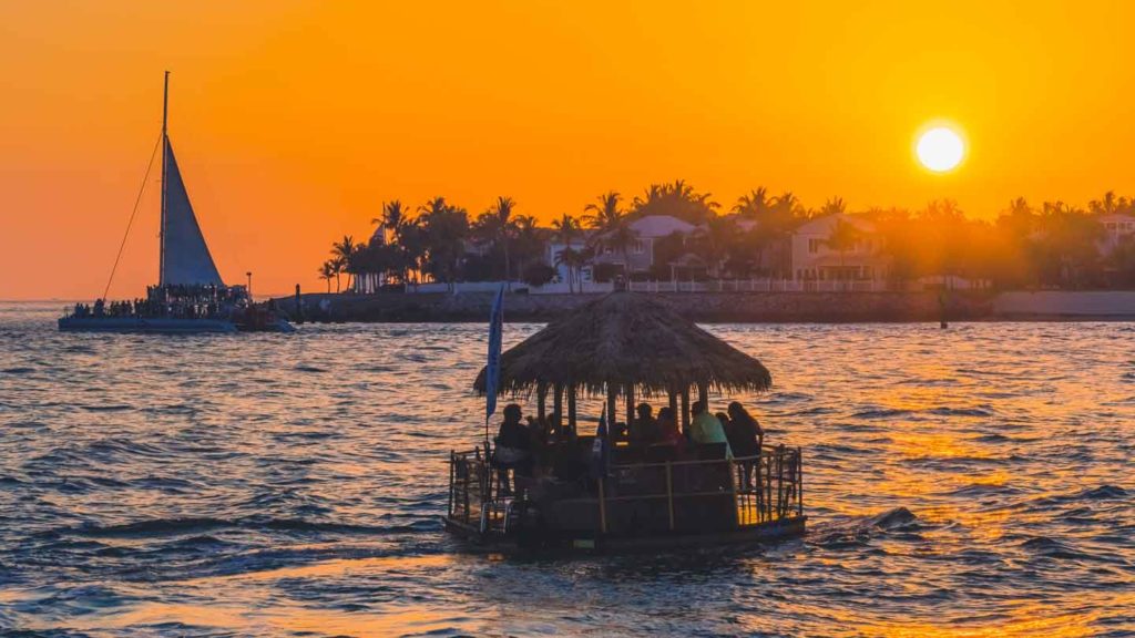 Floating tiki bar shaped like a traditional tiki hut sailing off the shores of Key West