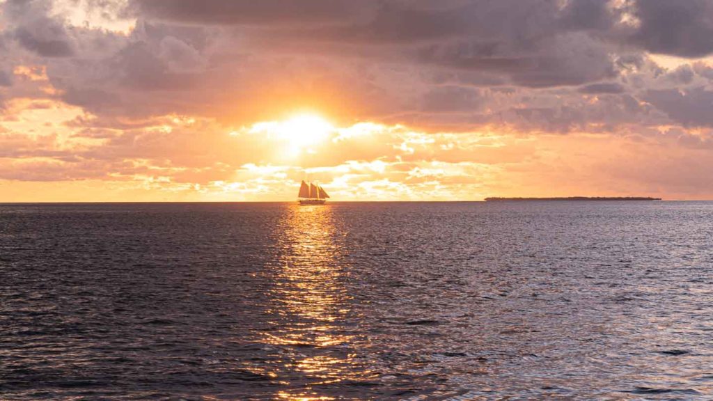 Large sailing ship on the water off shore of Key West florida during a orange and purple sunset - Things to do in Key West